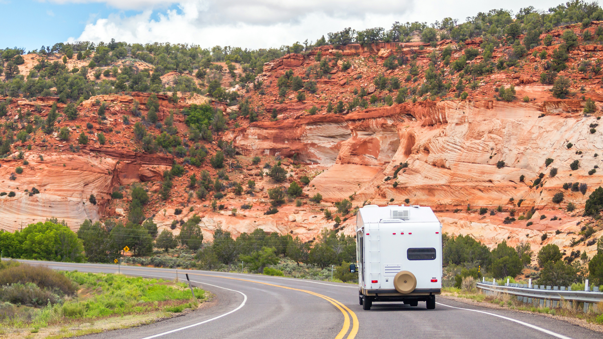 Camping-car circulant sur une route au cœur d’un paysage rocheux